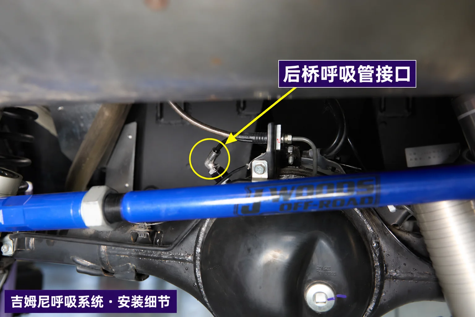 后桥呼吸管接口位置标注；与旁边的制动软管区分。